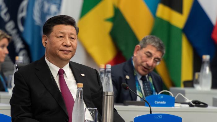 Мужчина в костюме перед флагами