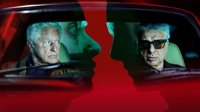 Портрет Иво Батича (Мирослав Немец, слева) и Франца Лейтмайра (Удо Вахтвейтль) в красной рамке.