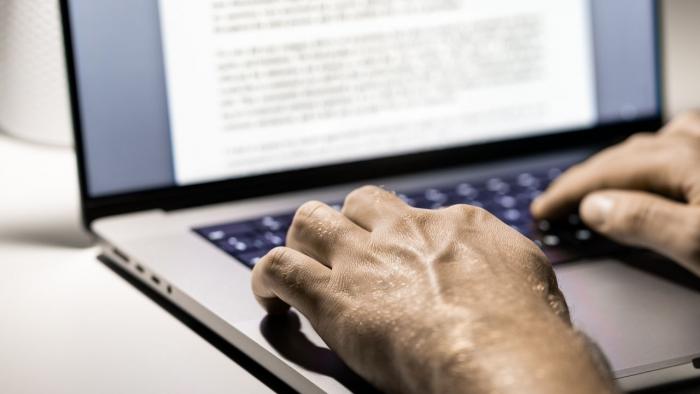 Рука на клавиатуре и экране